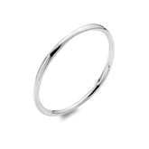 A close-up studio shot of a shiny, sterling silver bangle with a smooth, slightly rounded surface. The bangle is casting a small shadow on a white background.