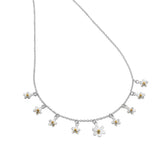 A silver charm necklace featuring multiple small daisies with yellow gold centres, suspended on a fine silver chain.
