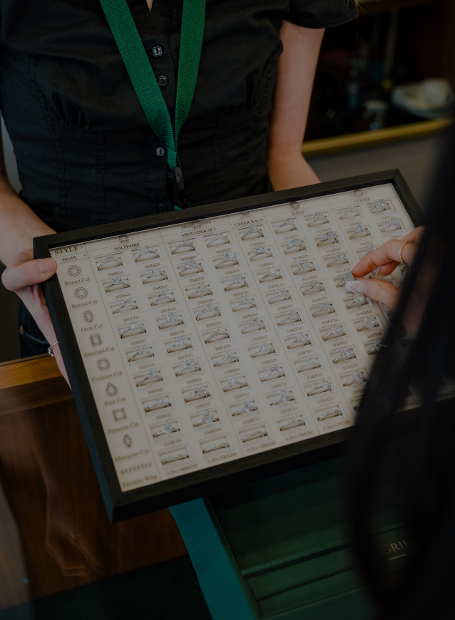 A display illustrating the variety of engagement ring styles available at Griffin & Co Fine Jewellery is shown to a customer.