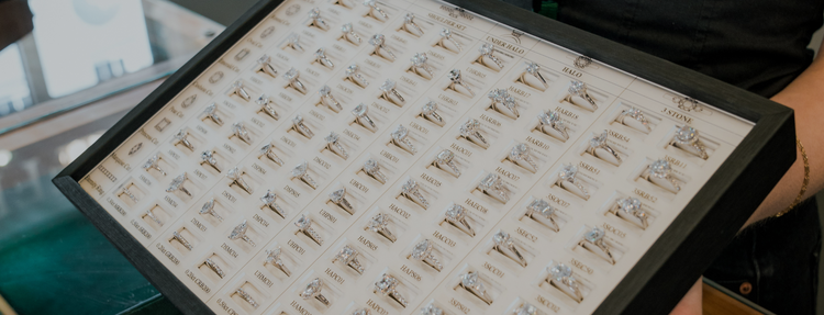 Multiple styles of diamond engagement rings arranged in a display case, at Griffin & Co Fine Jewellery.