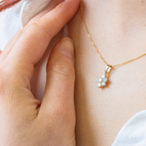 A model wearing a delicate and feminine lab-grown diamond flower pendant necklace in yellow gold from Griffin & Co, an example of our sustainable and ethical fine diamond jewellery.