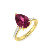 A large pear-cut pink tourmaline engagement ring with a diamond pavé band, crafted in 9ct yellow gold, on a white background.