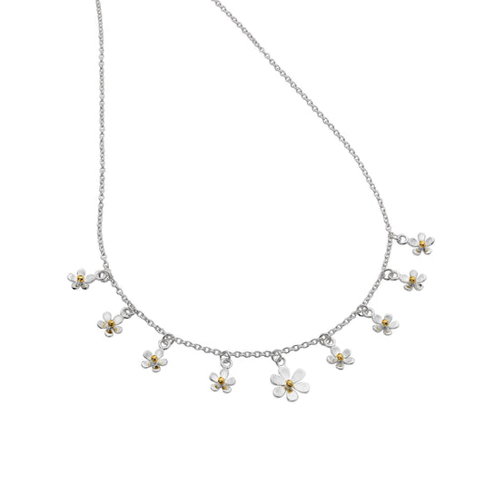 A silver charm necklace featuring multiple small daisies with yellow gold centres, suspended on a fine silver chain. 1800