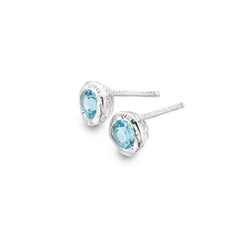 A pair of chunky, textured sterling silver stud earrings set with faceted blue topaz stones, shown on a white background.