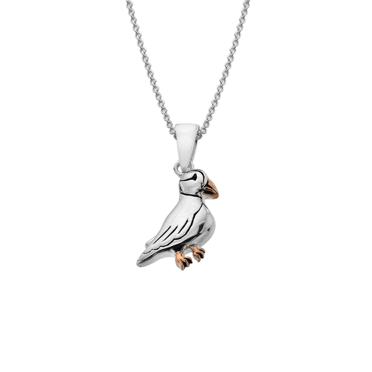 Studio shot of a handcrafted Sterling Silver puffin pendant with 18ct Rose Gold plated feet and beak.