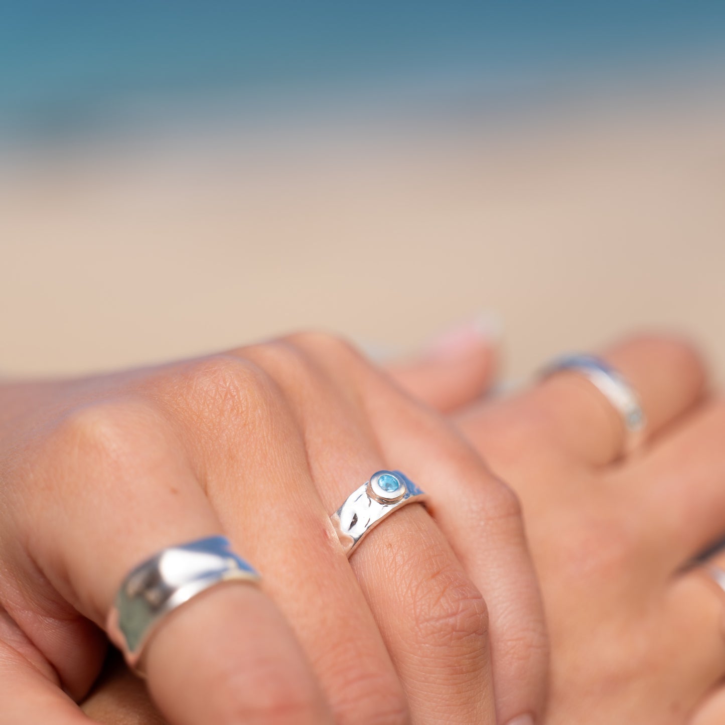 Close-up detail of sterling silver textured ring with blue topaz gemstone