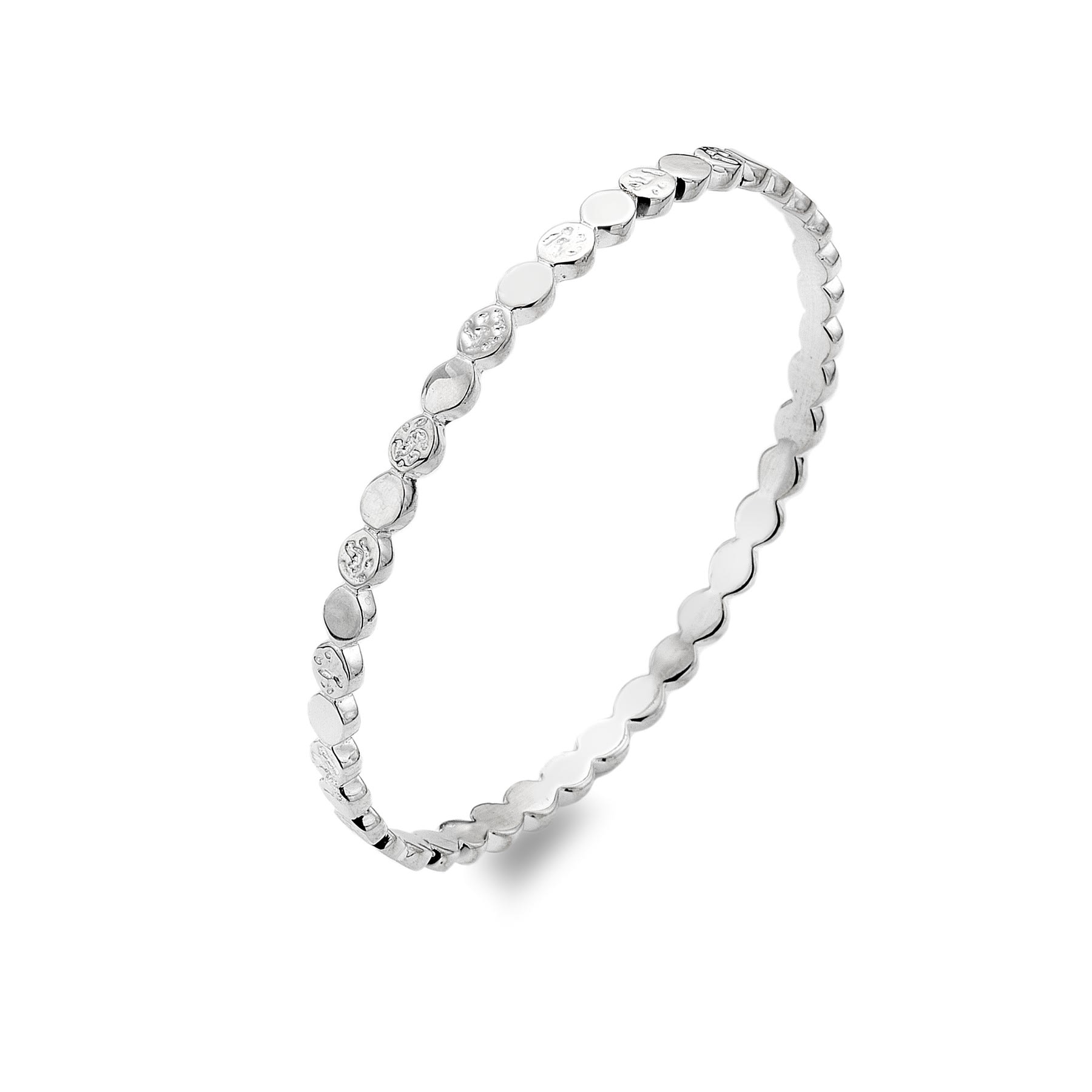 A studio shot of a shiny silver bangle with a repeating pattern of round, flat discs. Some discs are smooth, and others have a hammered texture.