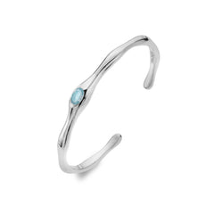 A slender, organic-shaped sterling silver cuff bangle featuring a central oval Sky Blue Topaz gemstone, on a white background.