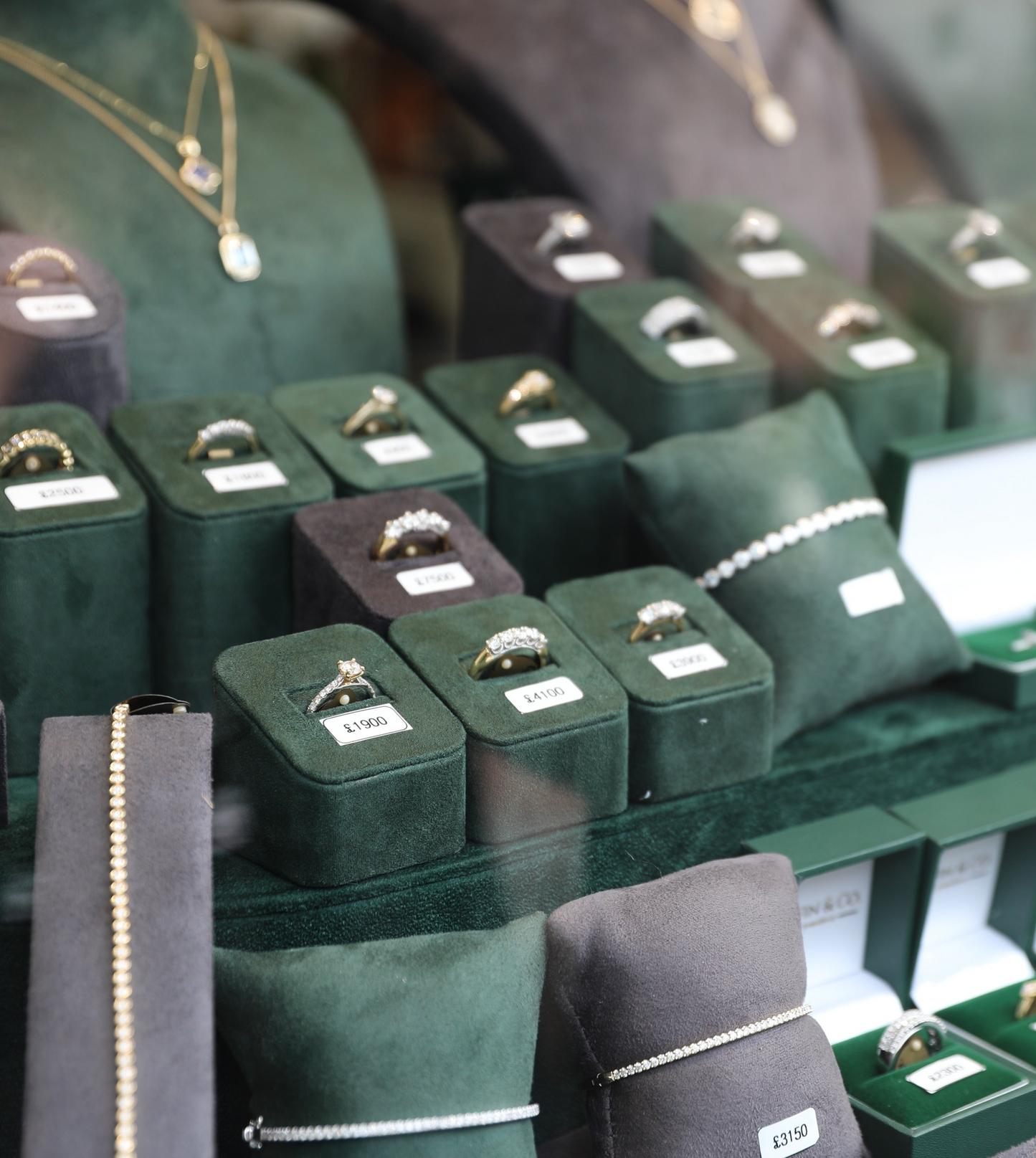 Display of rings in green boxes with labels in Griffin & Co's window.