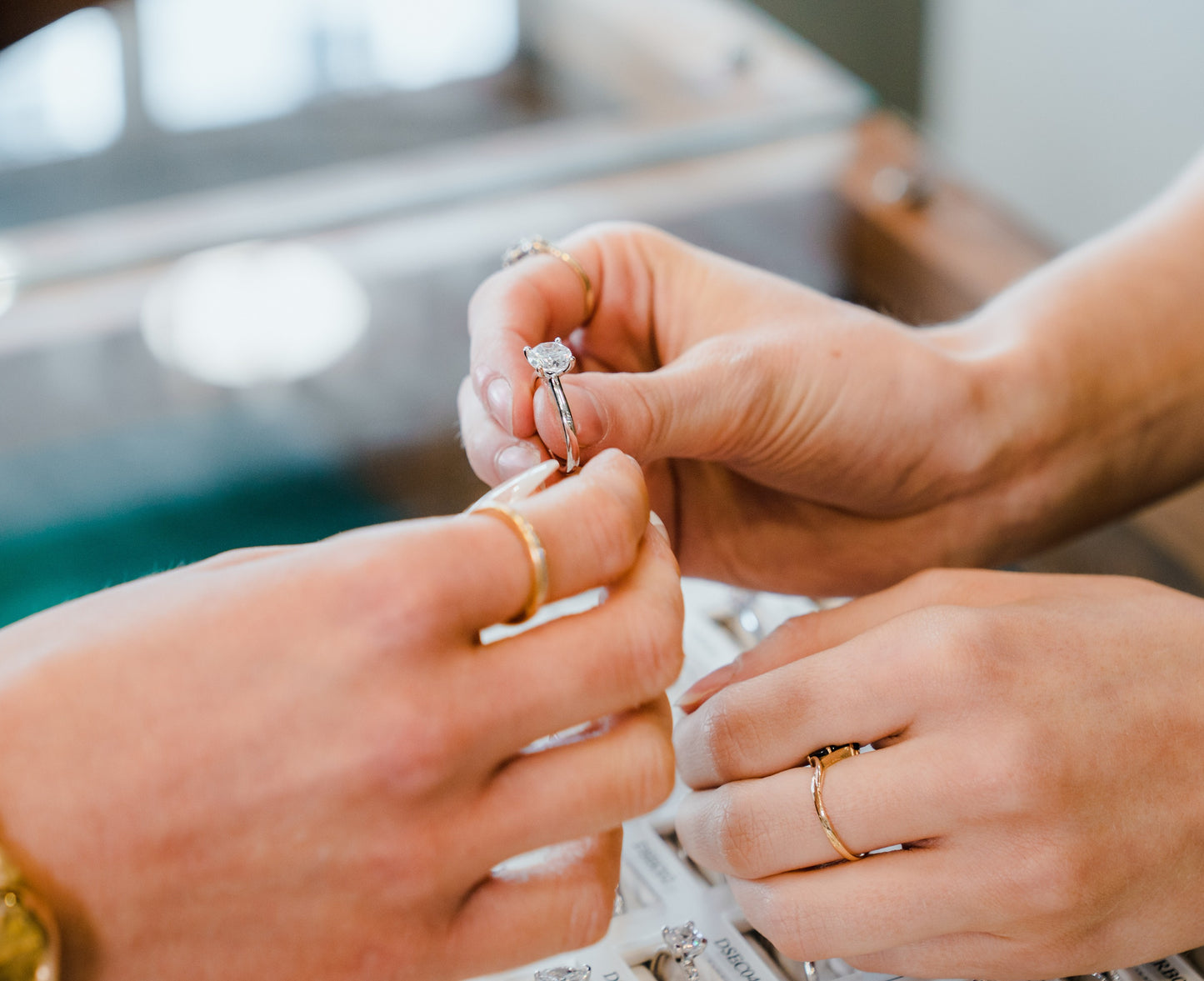 The process of choosing engagement rings at Griffin & Co Fine Jewellery, with hands carefully handling the jewellery.