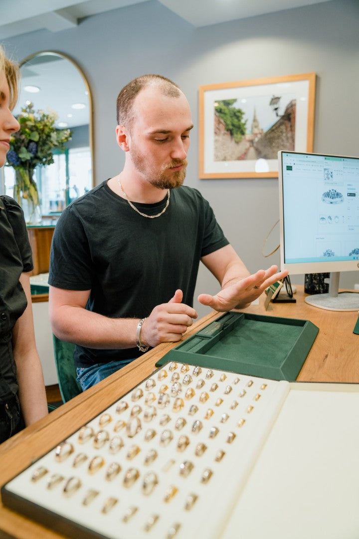 Two people examining a display of signet rings at Griffin & Co fine jewellery.
