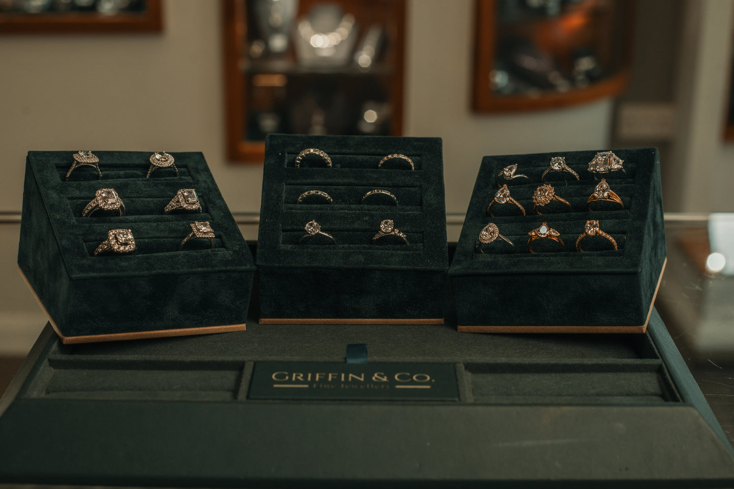 Display of engagement rings in a 'Griffin & Co' jewellery stand with a blurred background