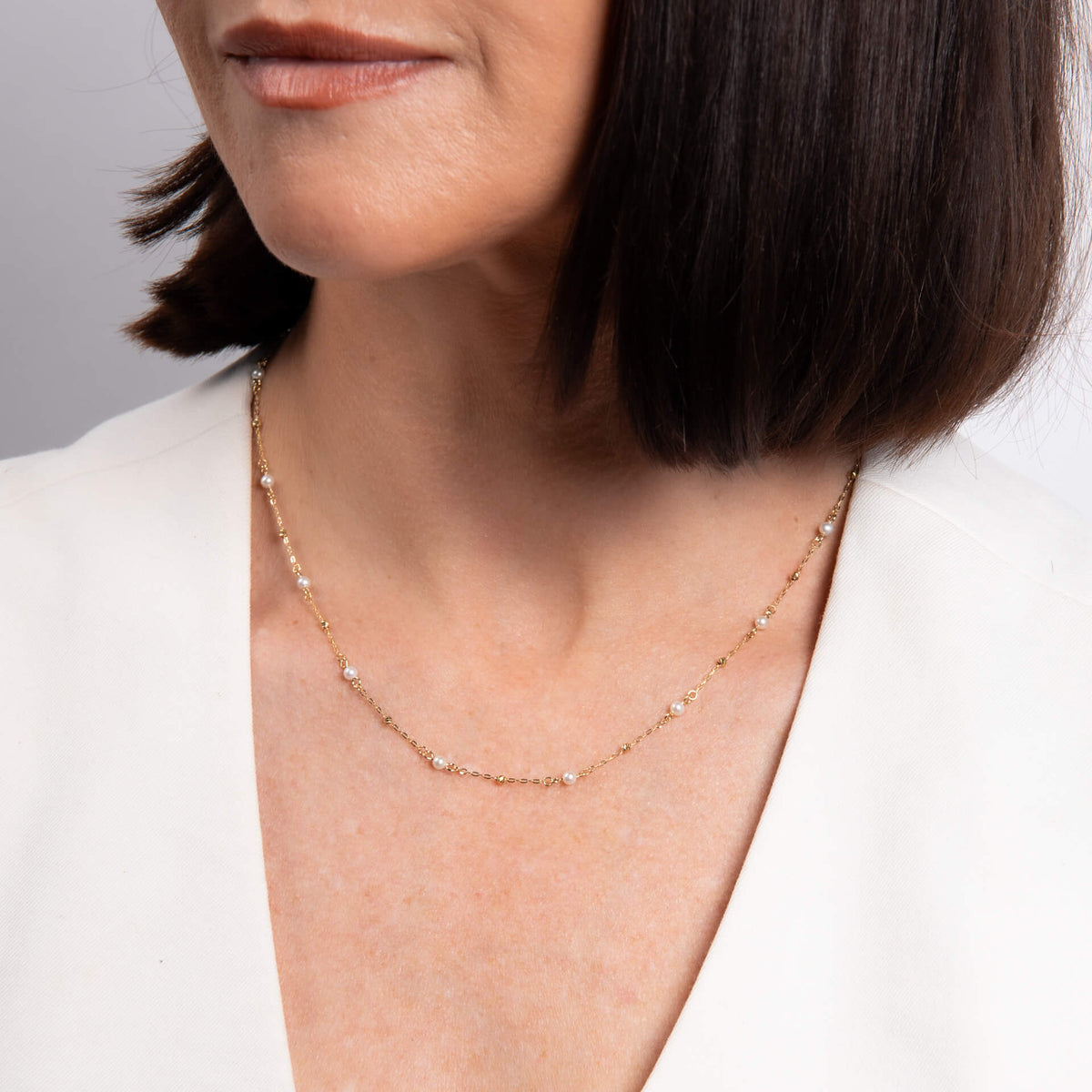 Model wearing the trace chain necklace with freshwater pearls