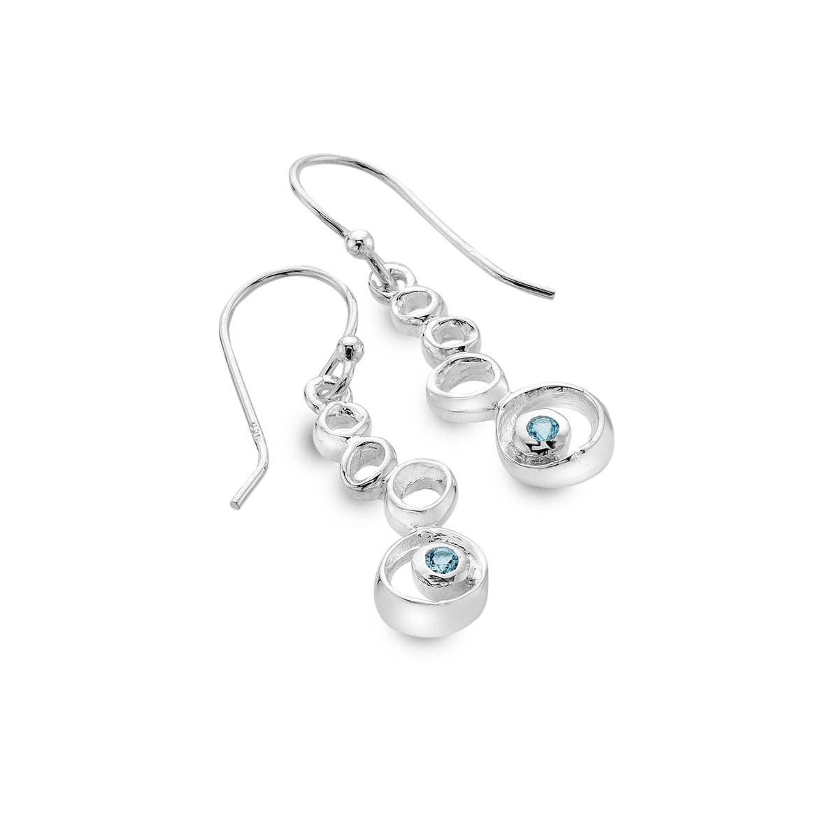 A pair of Silver Origins stacked pebble drop earrings in sterling silver, featuring a round blue topaz stone in the largest pebble, on a white background.