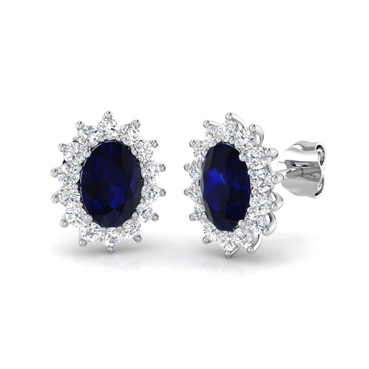 Pair of 9ct white gold halo earrings featuring oval lab grown blue sapphires surrounded by round lab grown diamonds. 1080