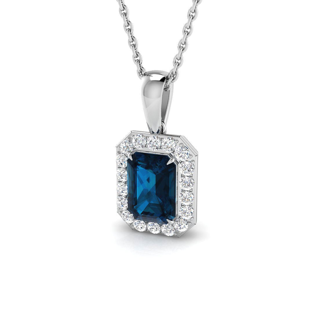 Close-up detail of emerald cut London blue topaz with diamond halo setting in white gold