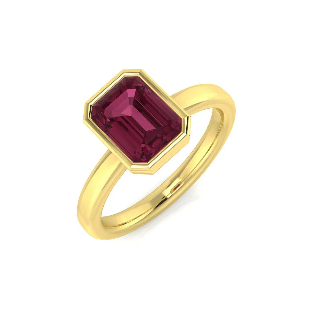 An emerald-cut pink tourmaline solitaire ring with a bezel setting, crafted in 9ct yellow gold, on a white background.