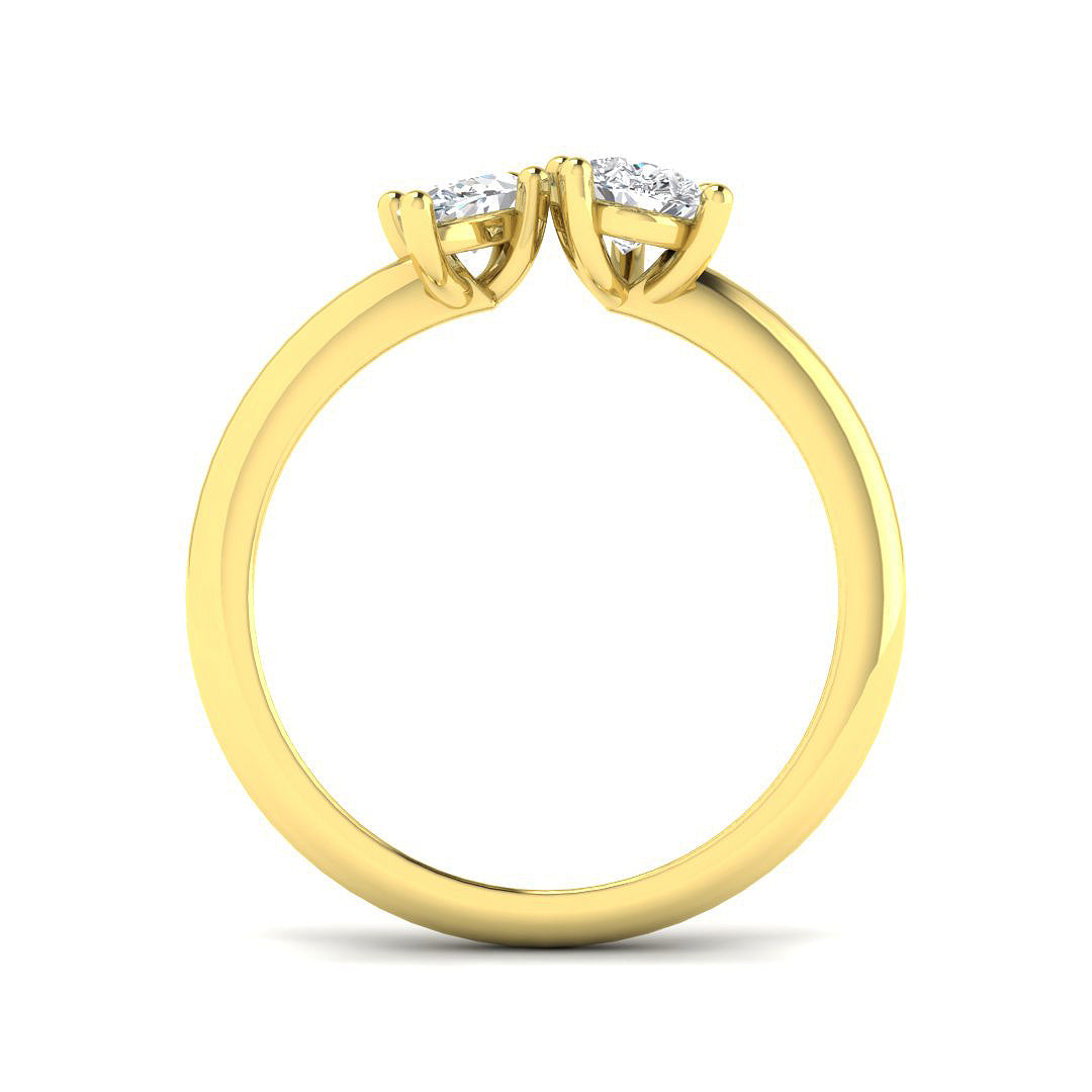 A side profile view of a two-stone diamond ring, showing the prong settings of the pear and marquise diamonds on a polished gold band.