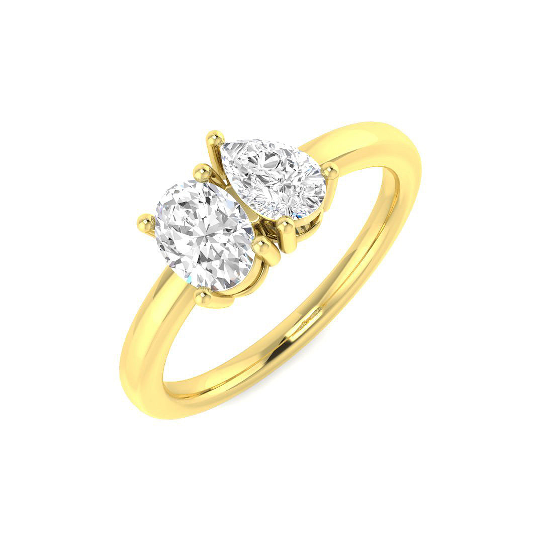 An angled view of an 18ct yellow gold Toi et Moi ring, showcasing a pear diamond and oval diamond duo.