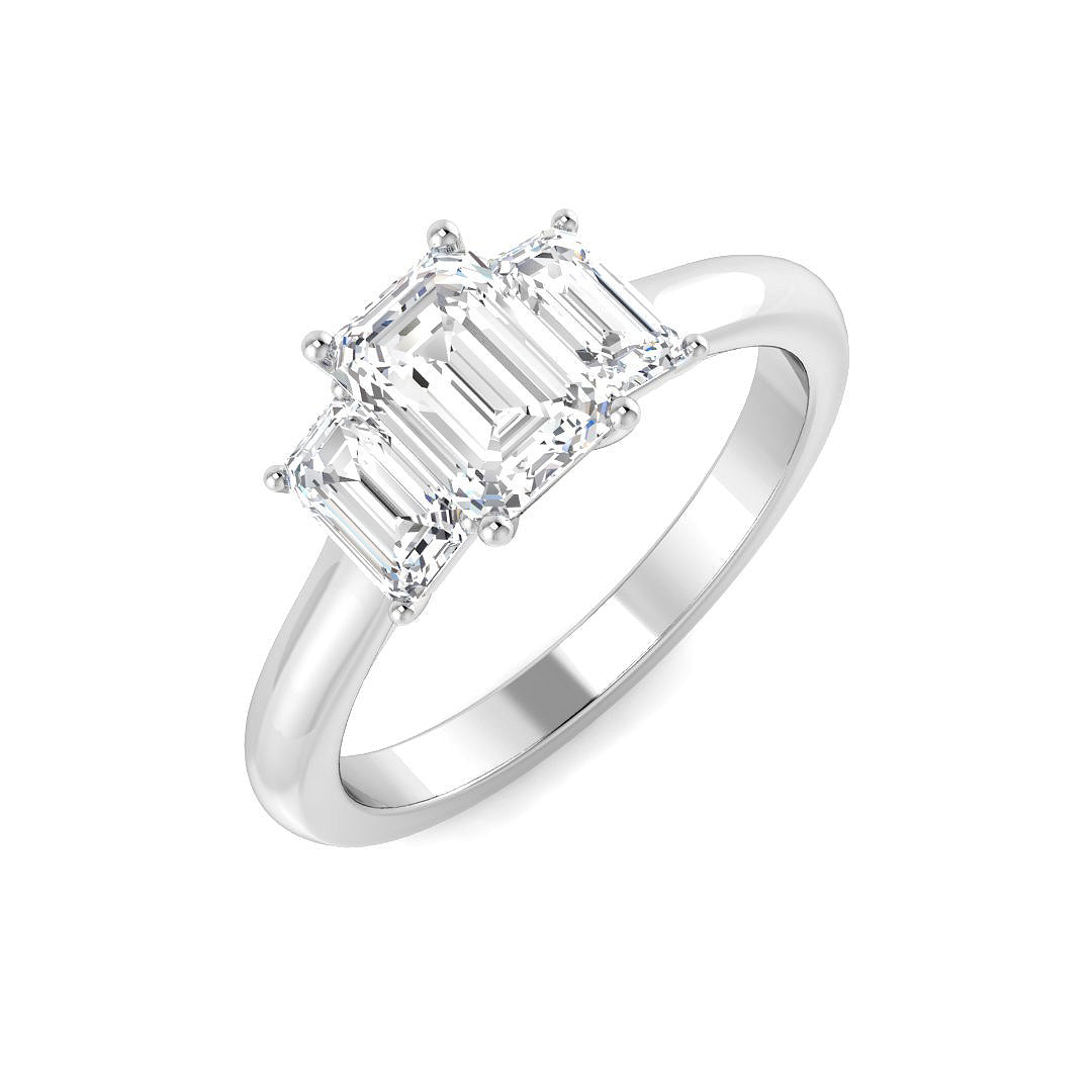 An angled view of a 9ct white gold trilogy engagement ring, featuring three graduated emerald cut lab grown diamonds held in white gold claw settings.