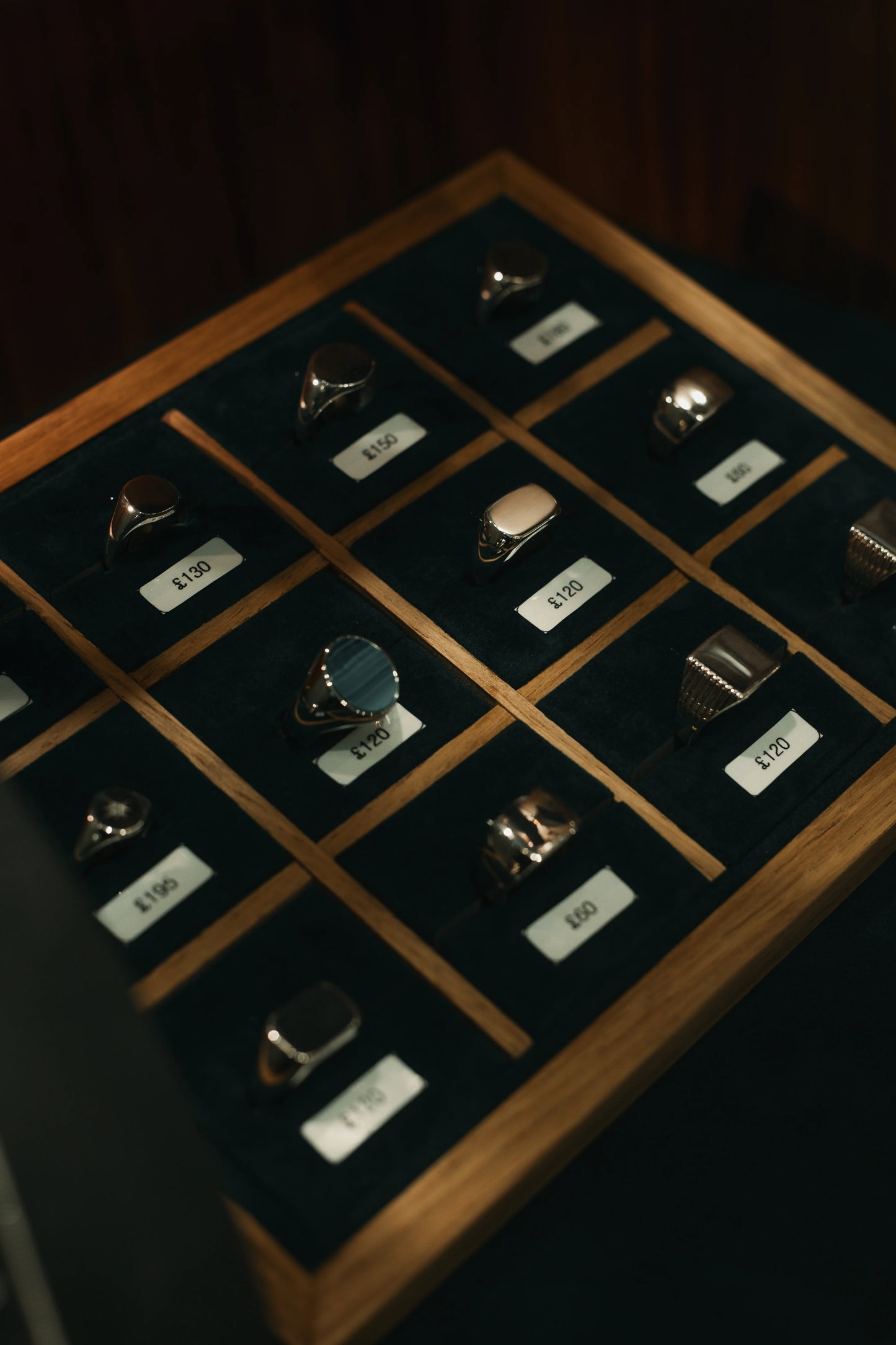 Collection of rings on a display board with price tags in a dark setting