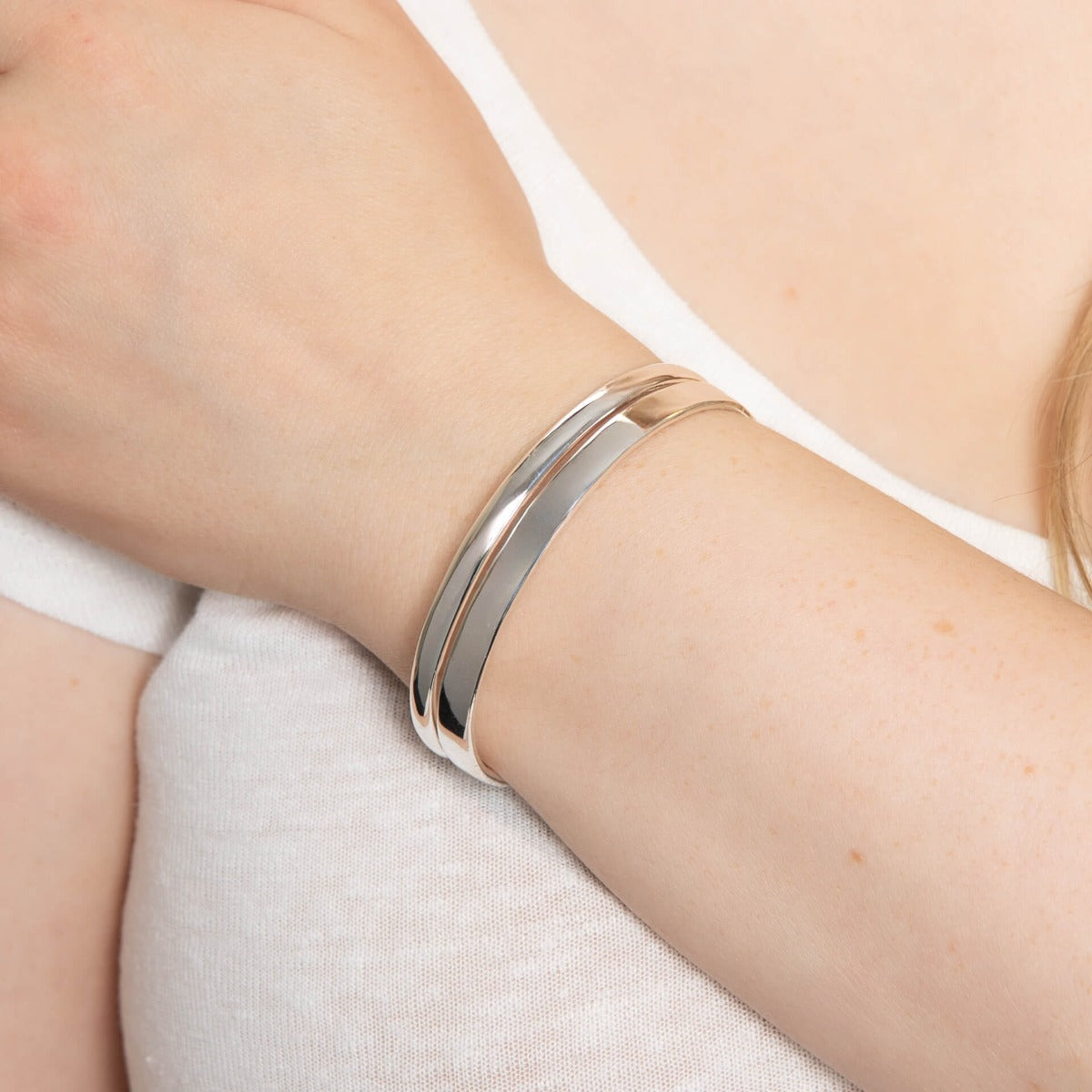 Model wearing the D-shape and flat torque bangle in recycled sterling silver