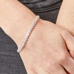 Silver beaded bracelet on a wrist with a neutral background