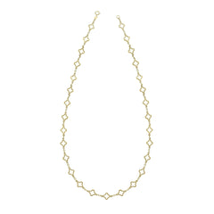 A close-up view of the gold quatrefoil station necklace, highlighting the detailed texture of the flower-like links.