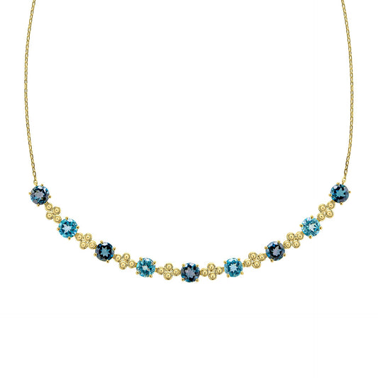 A close-up view of the blue topaz necklace, showing the detailed gold settings and the alternating shades of blue gemstones. 1920