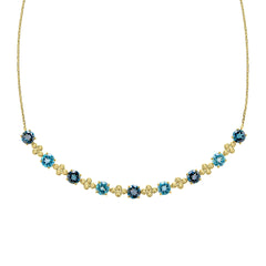 A close-up view of the blue topaz necklace, showing the detailed gold settings and the alternating shades of blue gemstones.