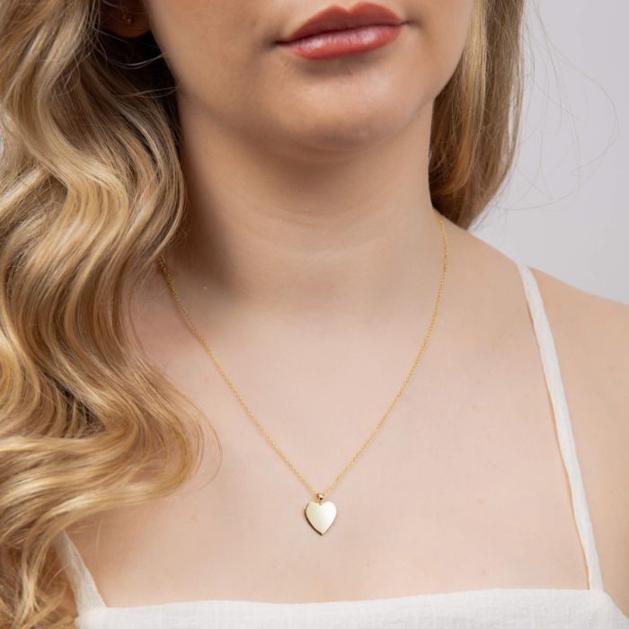 Model wearing heart engravable tag pendant in 9ct yellow gold