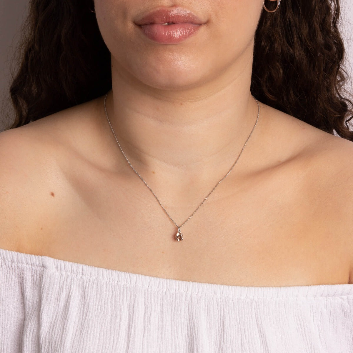 Model wearing asscher cut morganite and diamond pendant in 9ct white gold