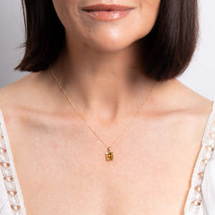 A close-up of a woman's neck wearing the gold citrine octagon pendant on a delicate chain.