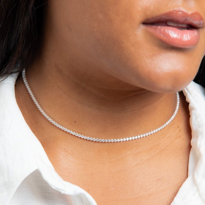 Close-up of a person wearing a delicate silver necklace.