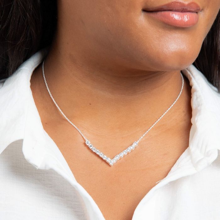 Silver necklace worn by a person with a white shirt