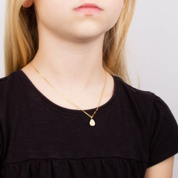 Model wearing droplet tag pendant in recycled sterling silver