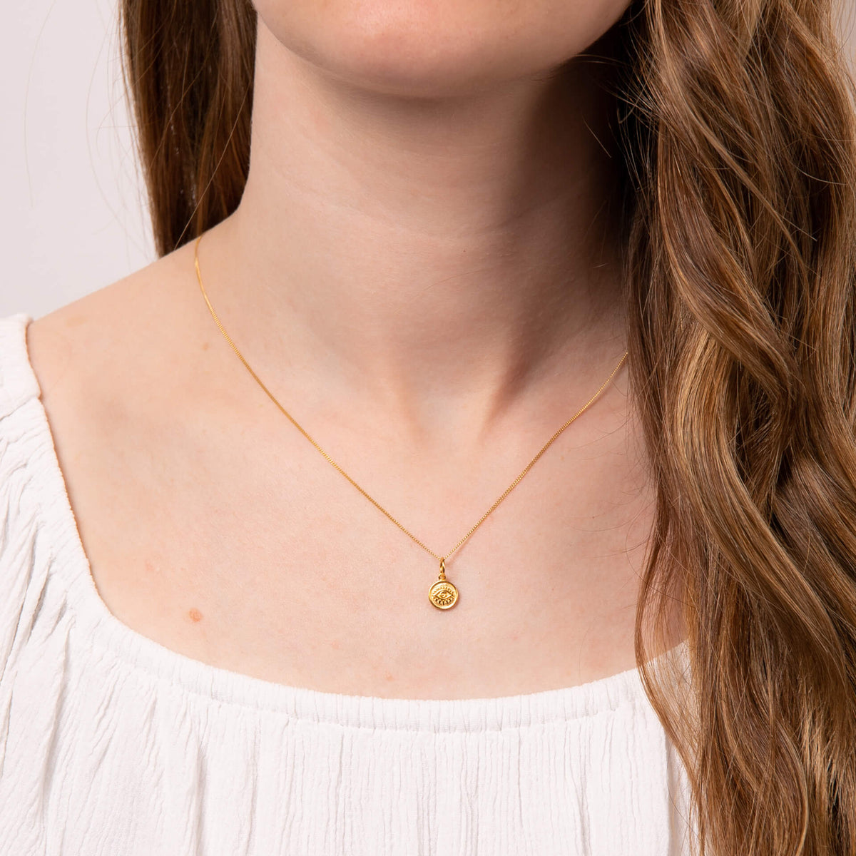 Evil eye pendant worn as necklace on model in recycled silver