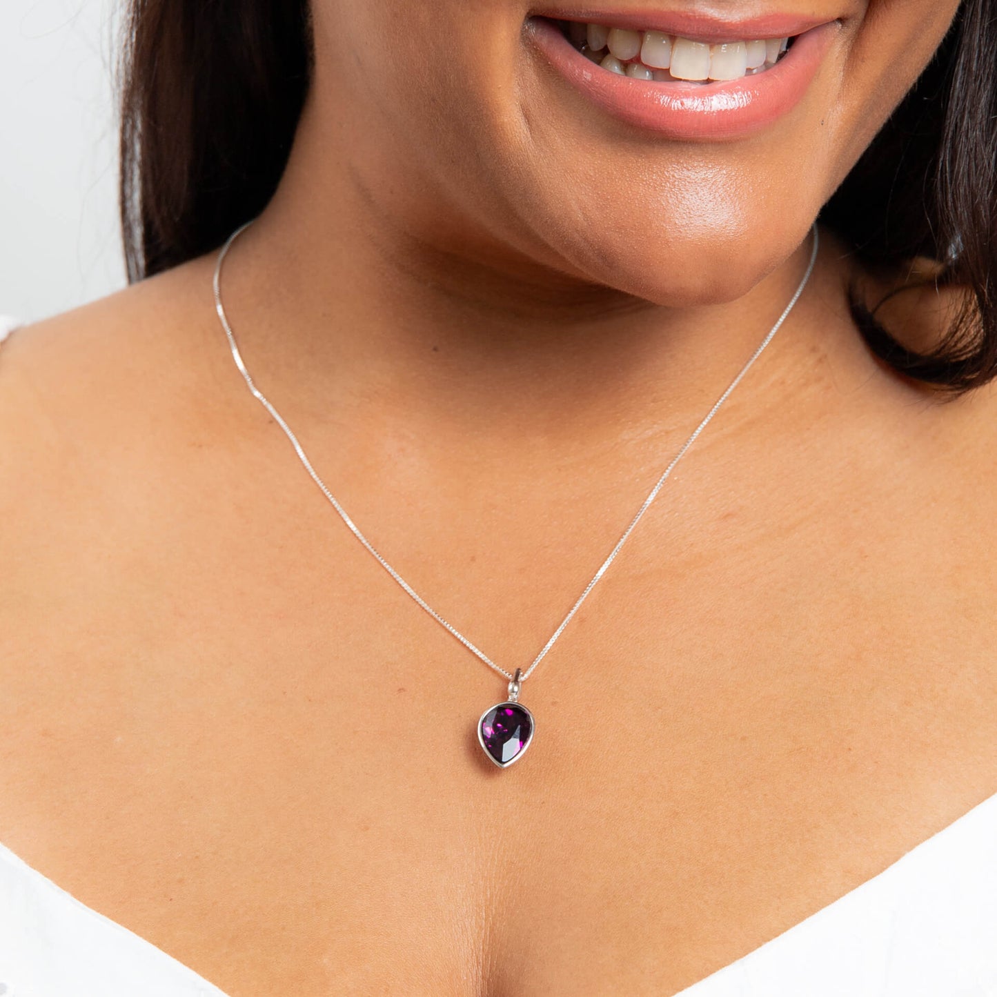 Model wearing pear shape amethyst crystal pendant in recycled sterling silver