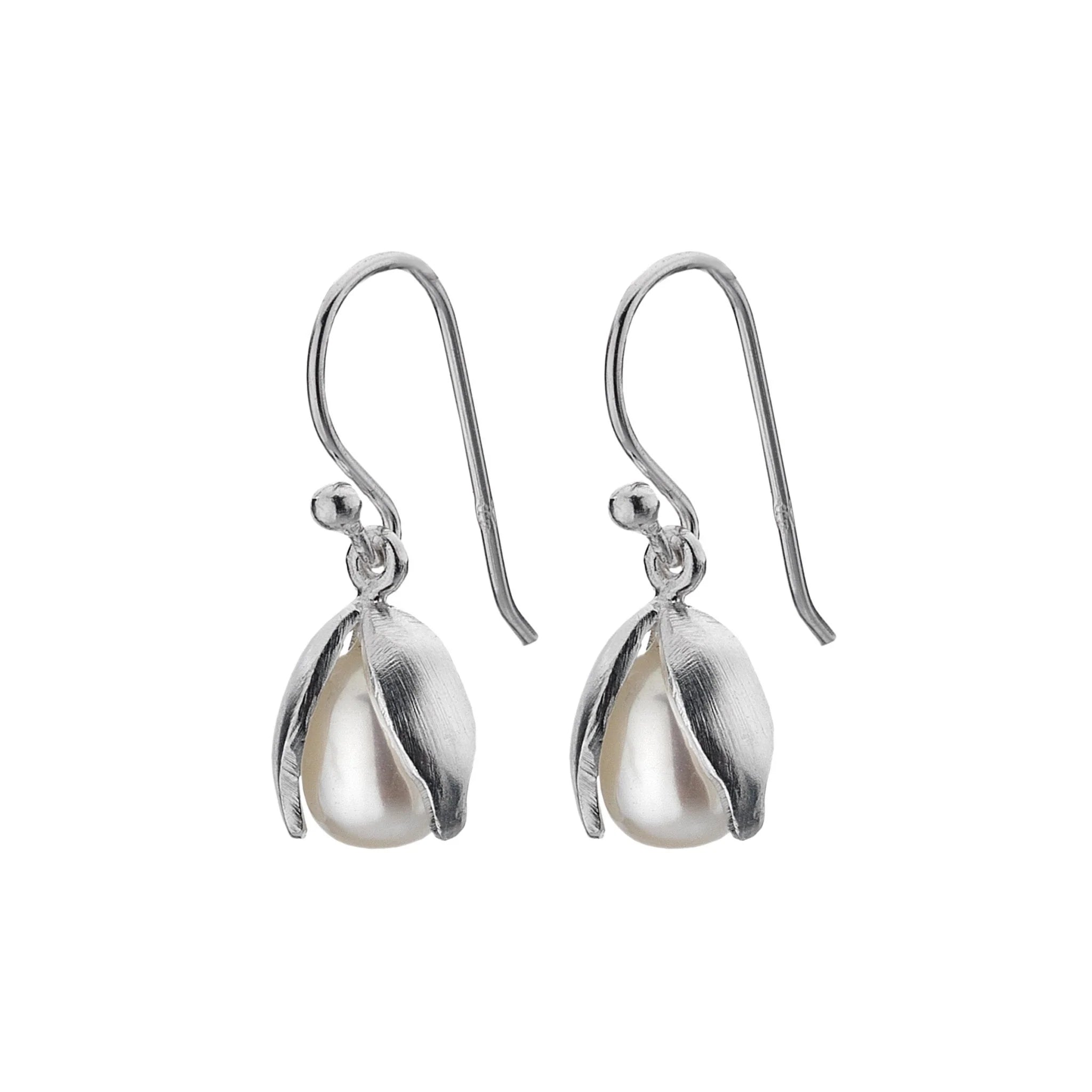 A close-up, high-angle shot of a pair of silver drop earrings shaped like snowdrop flowers. The "petals" are made of polished sterling silver and cradle a white freshwater pearl. The earrings are shown on a white background.