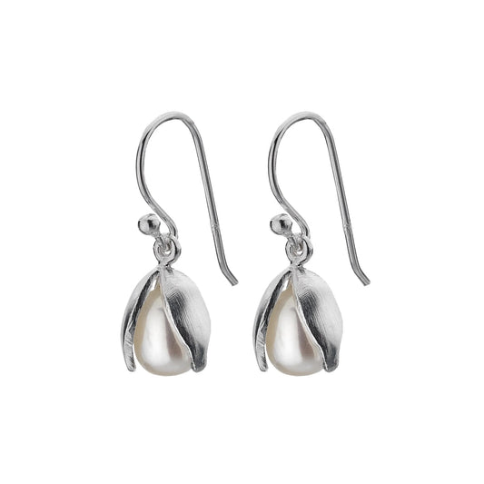 A close-up, high-angle shot of a pair of silver drop earrings shaped like snowdrop flowers. The "petals" are made of polished sterling silver and cradle a white freshwater pearl. The earrings are shown on a white background. 2048
