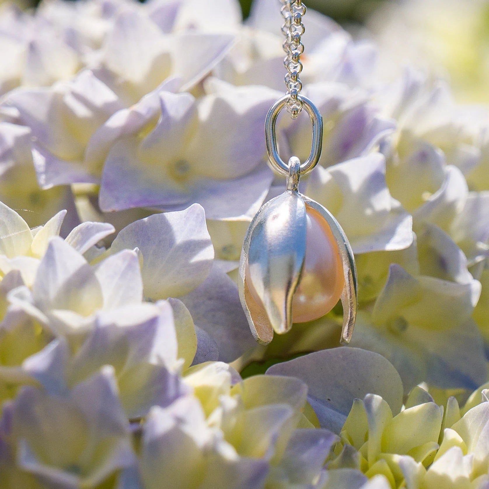 Pearl necklace hanging among hydrangea flowers