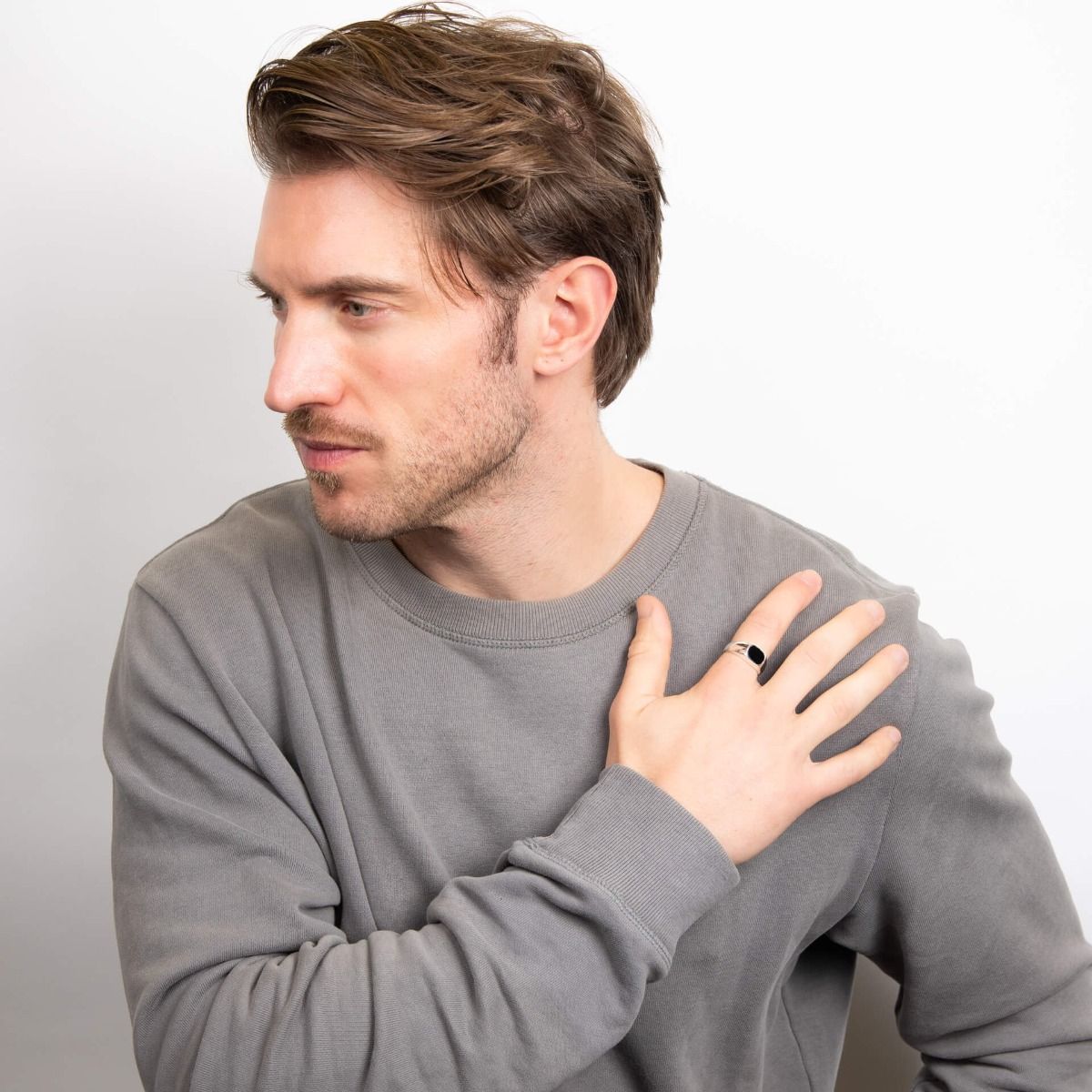 Man wearing a gray sweatshirt against a plain background