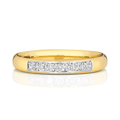A front view of a yellow gold grain set diamond ring, highlighting the row of brilliant cut stones.