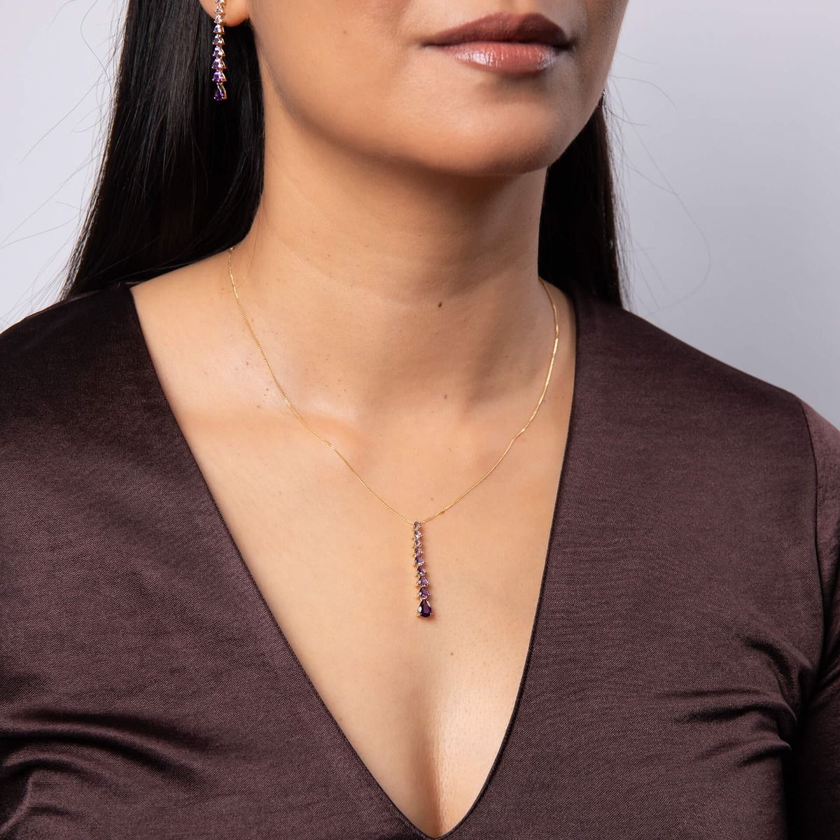 A close-up of a woman's neck wearing the 9ct gold cascading amethyst pendant necklace from the set.